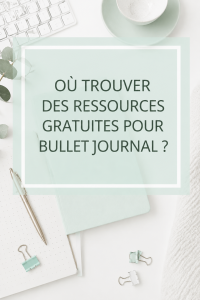 Une table avec un bullet journal ouvert et des fournitures créatives.